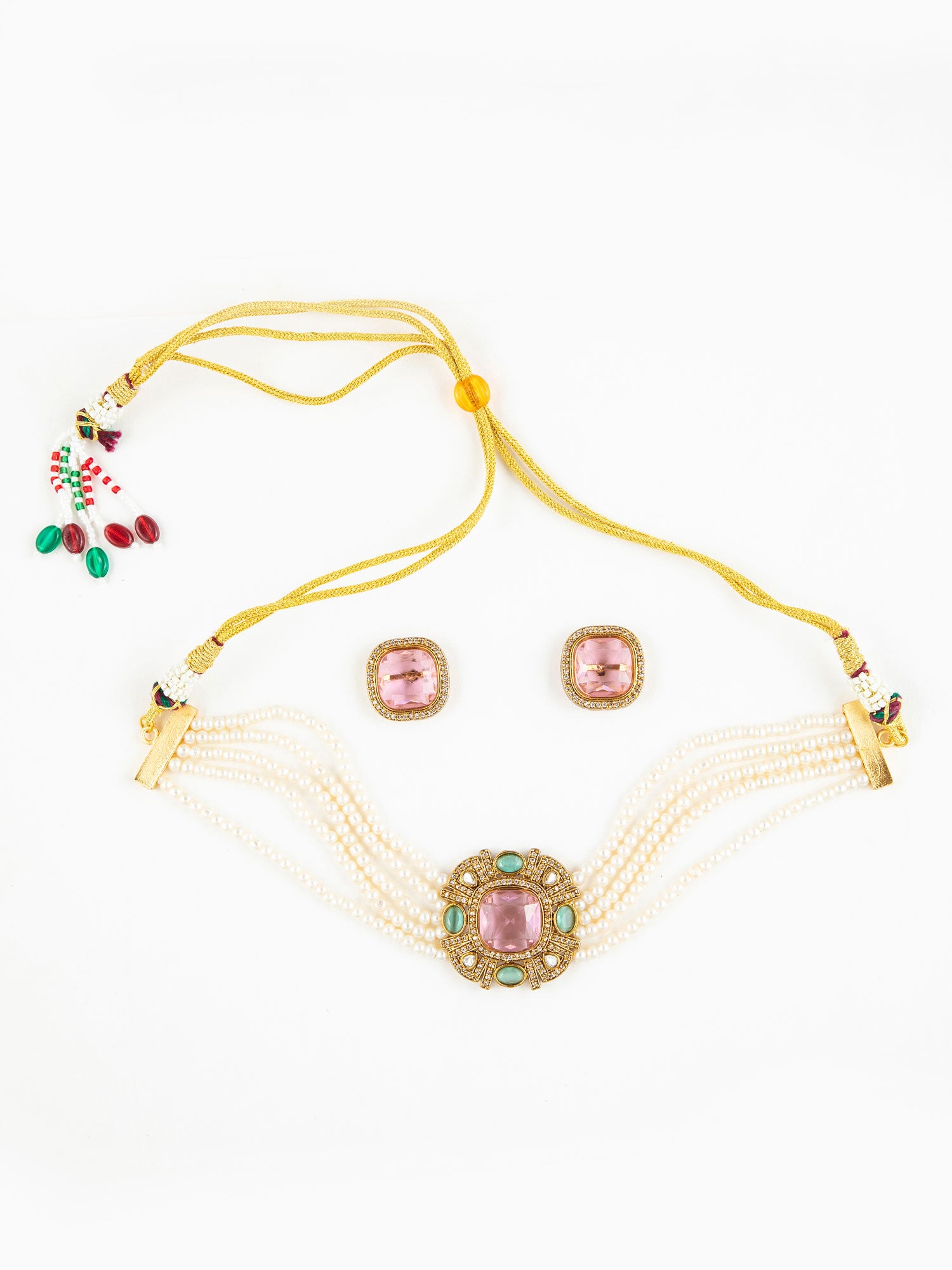 Jewelry set with a yellow thread, pink and green gemstones on a white background