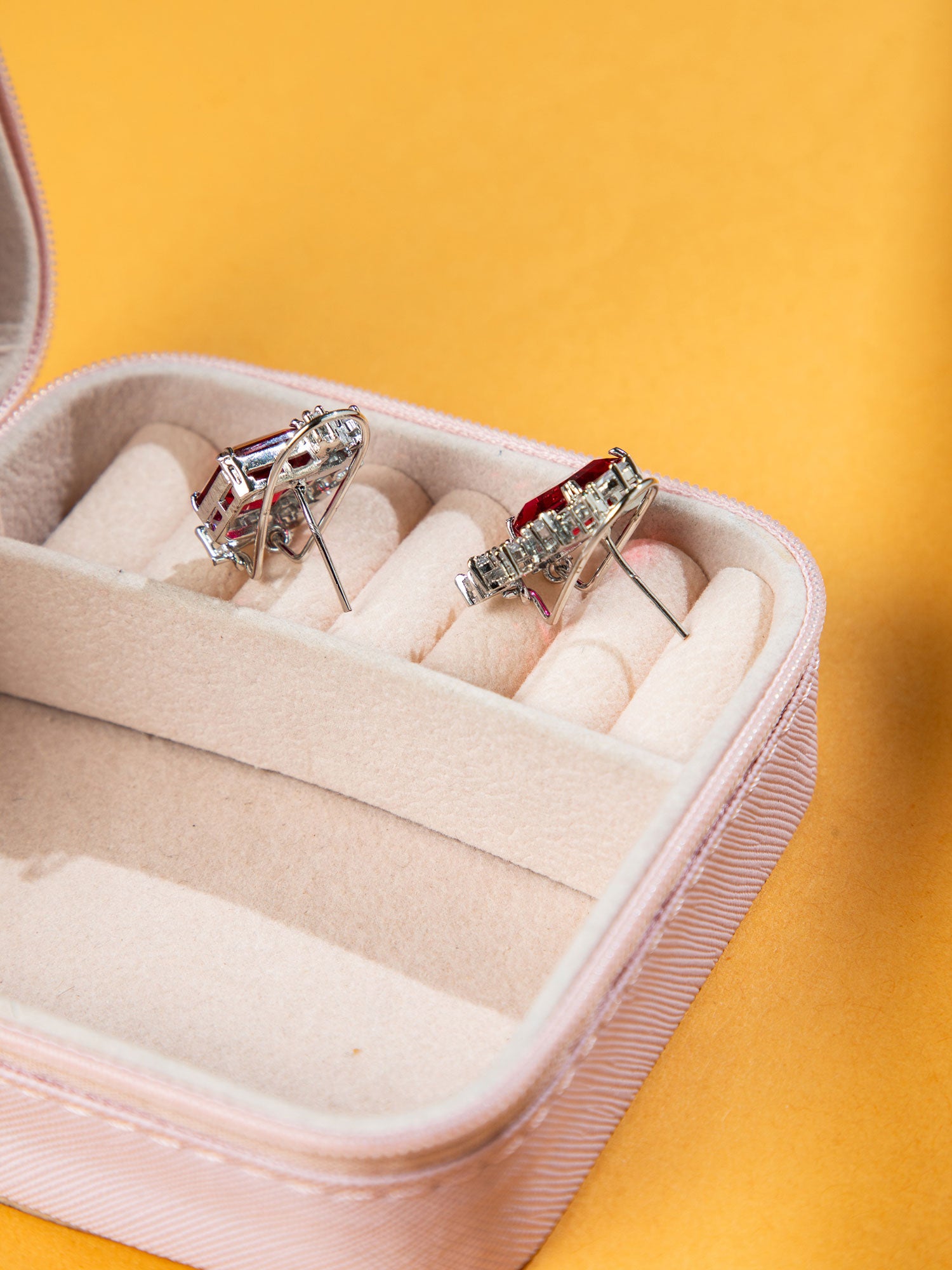 Rhodium Studs earrings in a jewelry box with a yellow background.