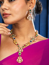 Woman wearing a peacock necklace set against a blue background