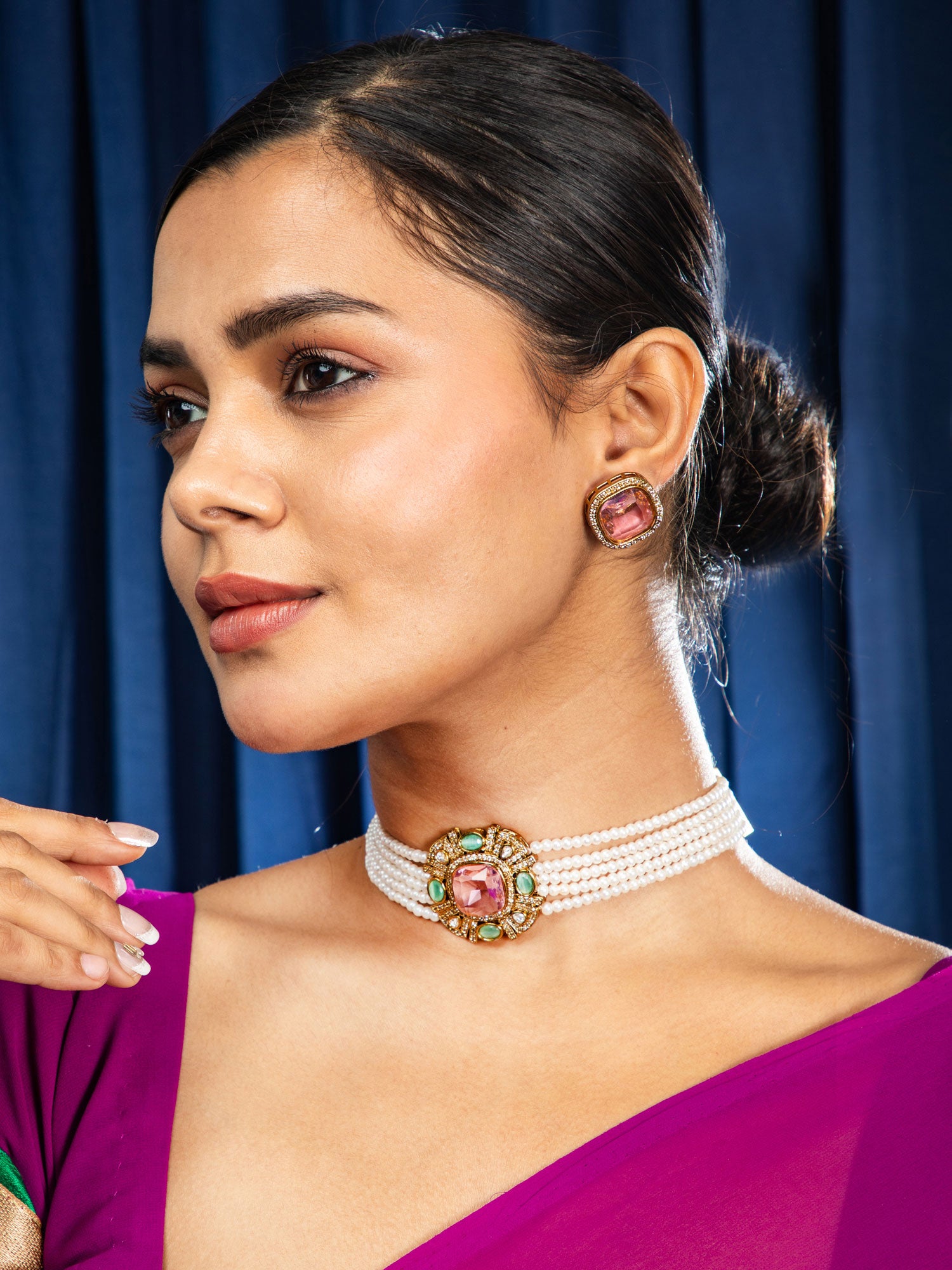 Woman wearing a decorative necklace with a blue curtain background