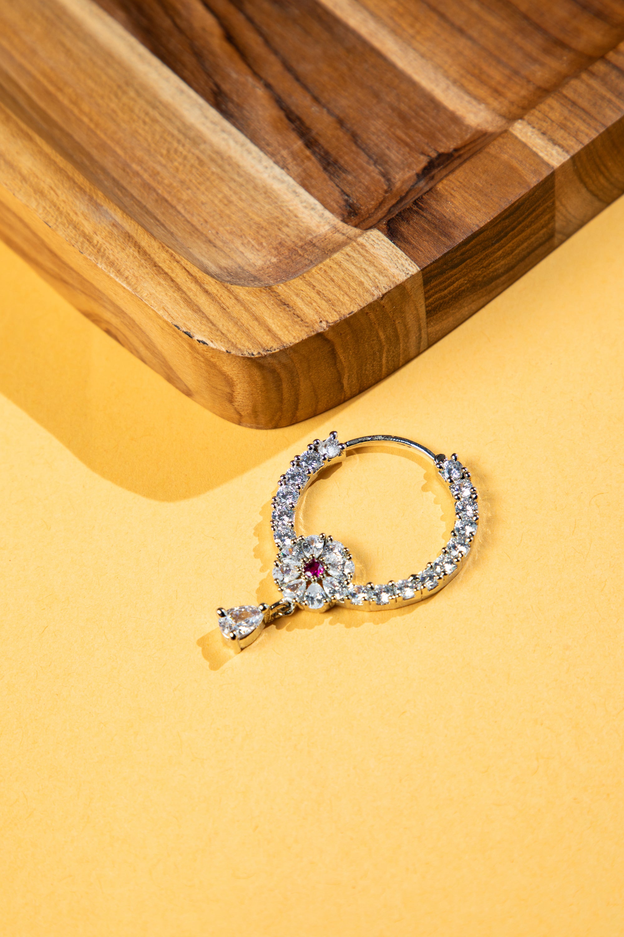 Elegant silver nose rings for women with sparkling CZ stones and red centerpiece.