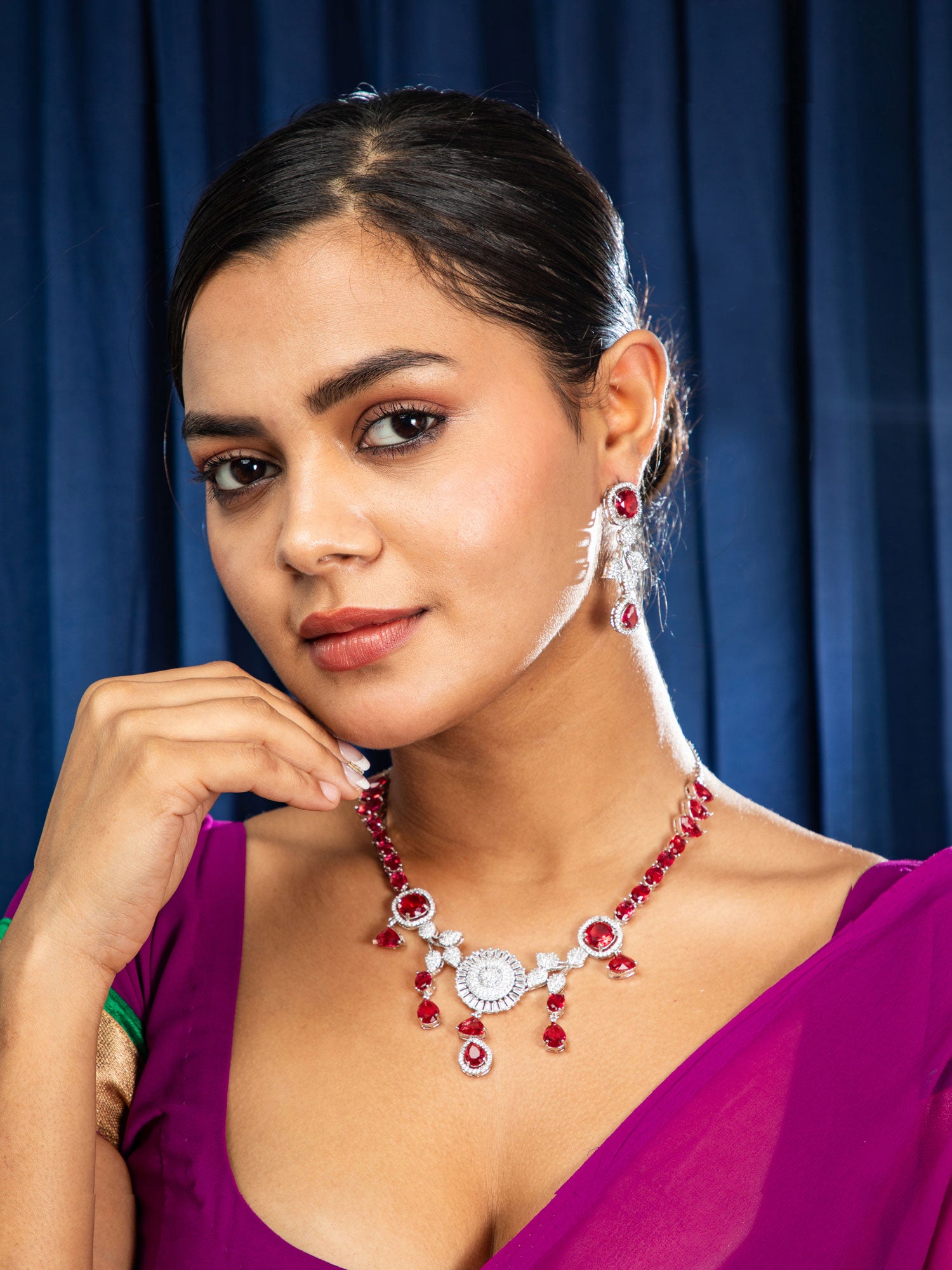 Women wearing modern red stone necklace set with elegant silver finish